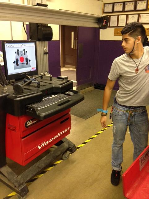 Endy Amaya 15 works with a professional diagnostic machine during Auto Tech. 