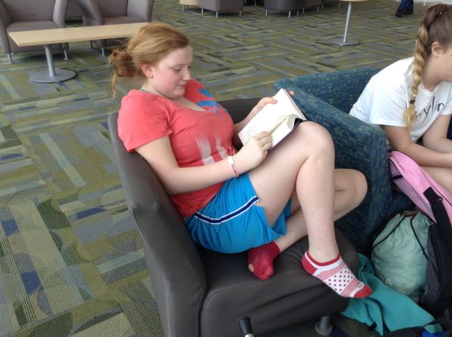 Freshman Shannon Kelly kicks off her shoes and gets comfy with a book in Town Hall at lunch. 
