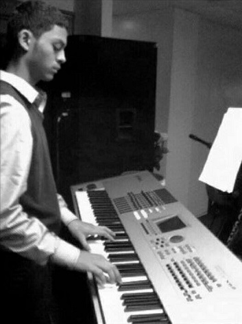 Josue Castro 16 reads music notes while practicing on his keyboard. 