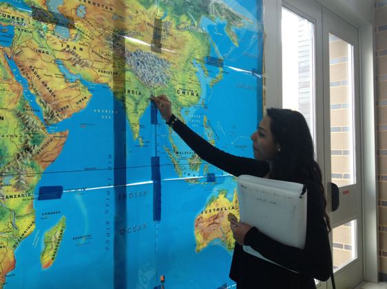 Senior Angelica Gomez reads the Wakefield Heritage week map. Students flagged places all over the world where they have come from. 