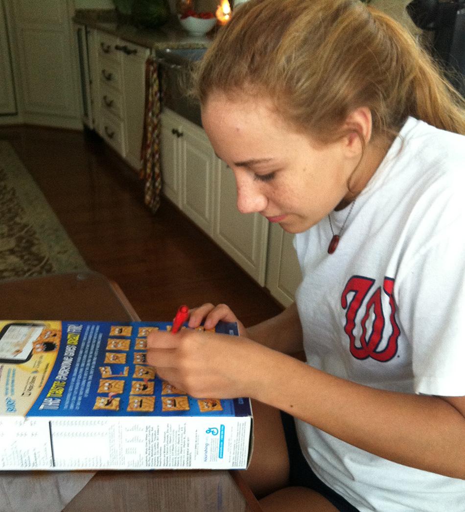 Sophomore Olivia Ceccato reads and completes the games on the back of her Cinnamon Toast Crunch cereal box.