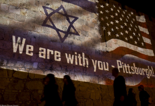 People walk past a projection on the Old City wall in Jerusalem, Sunday, Oct. 28, 2018 in a commemoration of the victims of a deadly shooting at a Pittsburgh synagogue.